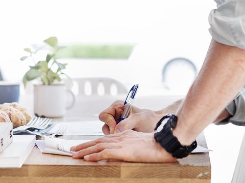 Iemand ondertekent een papier aan tafel
