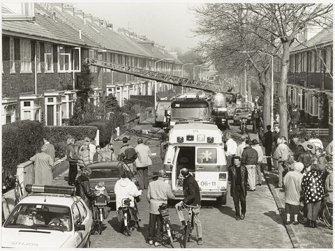Brandweer en hulpdiensten in een straat bij een woningbrand